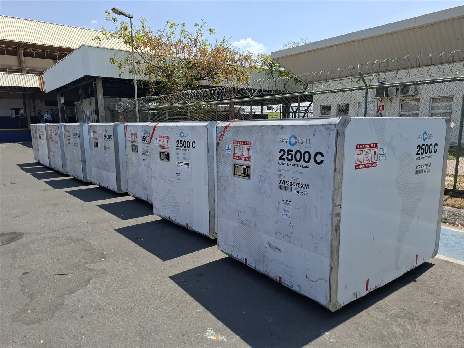 Desembarque controlado de aeronave cargo no aeroporto com equipe técnica acompanhando descarga das vacinas
